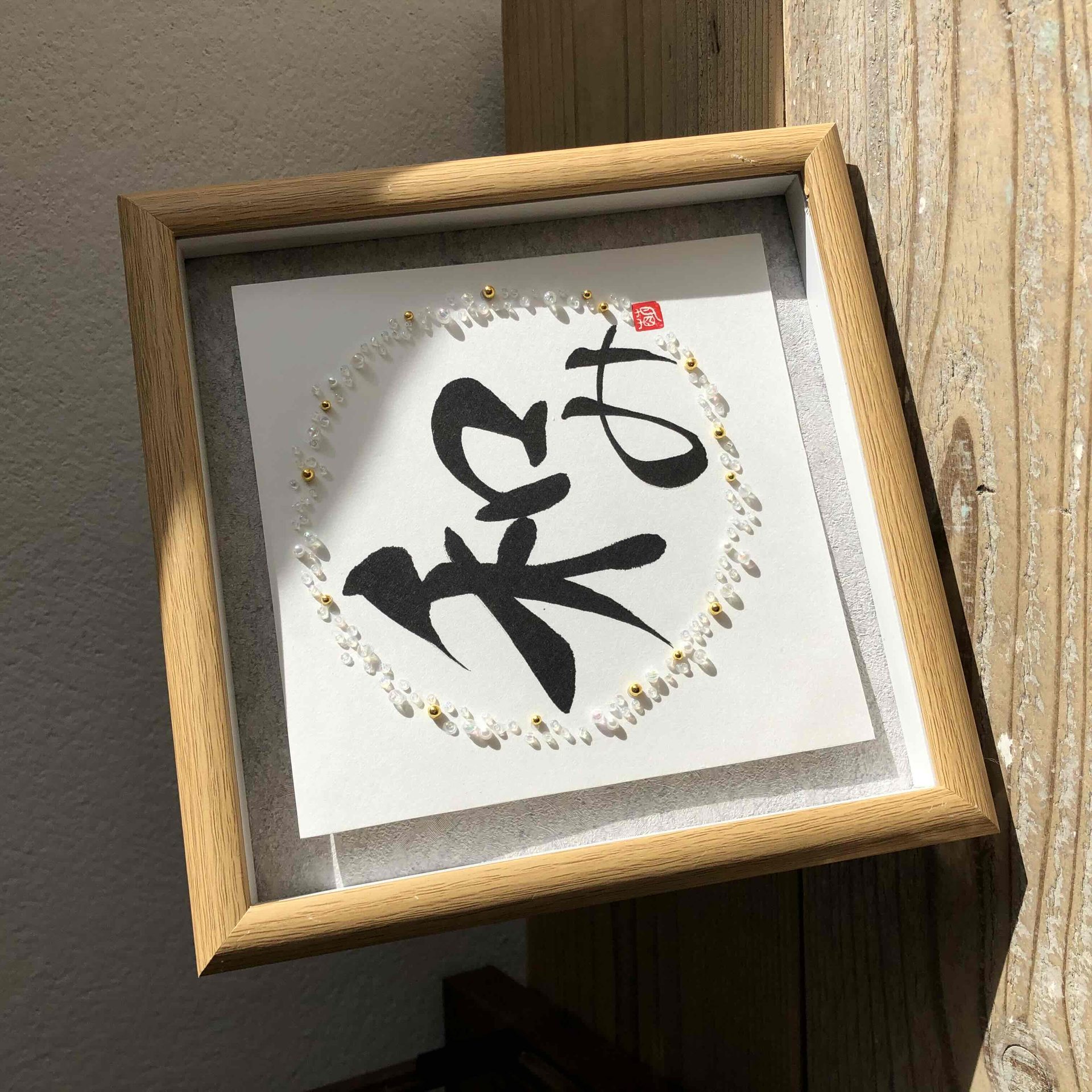ビーズで縁取られた書の作品